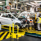 Employees wearing protective masks against the spread of the novel coronavirus, COVID-19, work along the assembly line that produces both the electric vehicle Renault Zoe and the hybrid vehicle Nissan Micra, at Flins-sur-Seine, the largest Renault production site in France on May 6, 2020